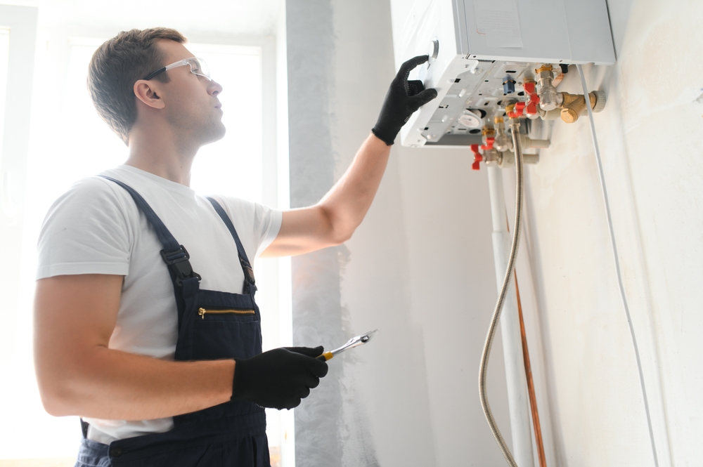 Engineer checking boiler pipes during a service